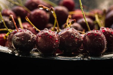 Su sıçratan kiraz siyah arkaplan.