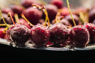 Su sıçratan kiraz siyah arkaplan.