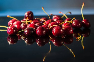 Su sıçratan kiraz siyah arkaplan.