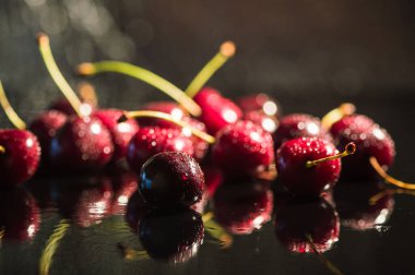 Su sıçratan kiraz siyah arkaplan.