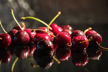 Su sıçratan kiraz siyah arkaplan.