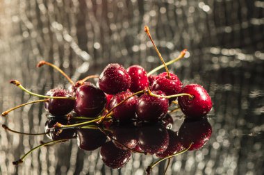 Su sıçratan kiraz siyah arkaplan.