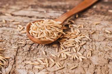 Yuvarlanmış yulaf ve yulaf taneleri ahşap bir masada, boşluğu kopyala.
