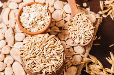 Tahta bir masanın üzerindeki yulaf lapası, yulaf ezmesi. Cömert hasat. Sağlıklı taze bir kuru yulaf yemeği. 