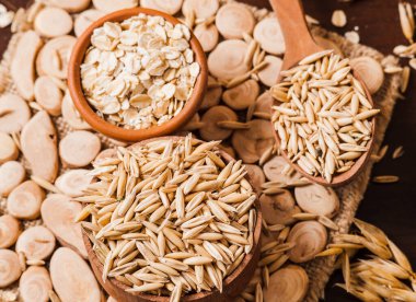 Tahta bir masanın üzerindeki yulaf lapası, yulaf ezmesi. Cömert hasat. Sağlıklı taze bir kuru yulaf yemeği. 