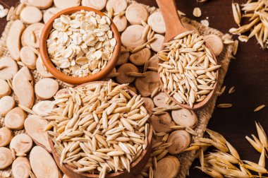 Tahta bir masanın üzerindeki yulaf lapası, yulaf ezmesi. Cömert hasat. Sağlıklı taze bir kuru yulaf yemeği. 