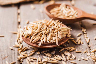 Tahta bir masanın üzerindeki yulaf lapası, yulaf ezmesi. Cömert hasat. Sağlıklı taze bir kuru yulaf yemeği. 