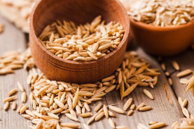 Tahta bir masanın üzerindeki yulaf lapası, yulaf ezmesi. Cömert hasat. Sağlıklı taze bir kuru yulaf yemeği. 