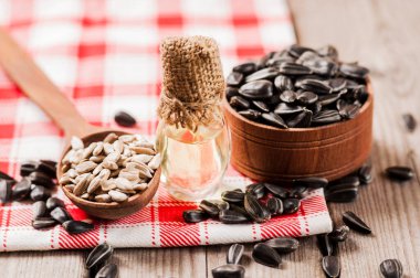 Taze ayçiçeği tohumu ve yağ. Tahta kasede kabuklu ayçekirdeği..