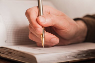 İş adamı bir deftere, rutine, iş planına yazar 