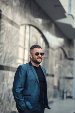 Takım elbiseli ve güneş gözlüklü şık bir adam..