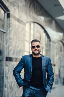 Takım elbiseli ve güneş gözlüklü şık bir adam..