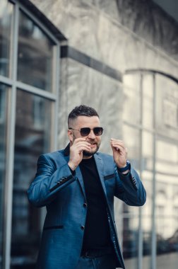 Takım elbiseli ve güneş gözlüklü şık bir adam..