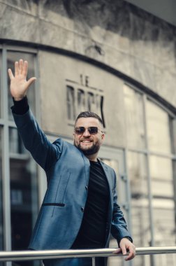 İş adamı toplantı için bekliyor. Adam el sallıyor..