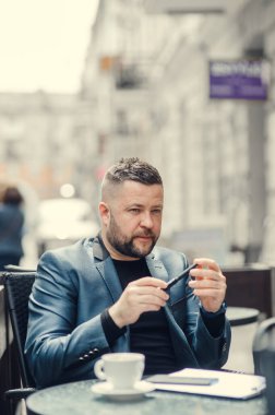 İş adamı bir iş planı yazıyor, ne yapacağını düşünüyor. Mavi takım elbiseli bir adam masada oturuyor..