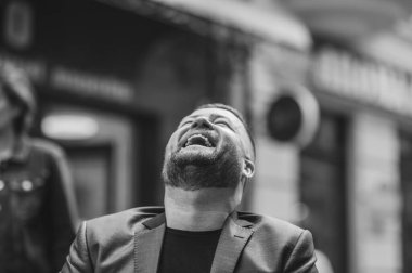 Genç, sakallı iş adamı kahvecide oturuyor..