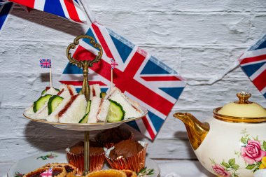 Platinum Jubilee  vintage  tea part  celebrations  with flags   of the  Union Jack   and  party  food  and  vintage  tea set 