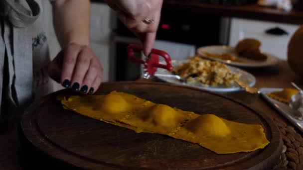 Close-up de mãos femininas cortando a massa para ravioli de abóbora e pastelaria. ravioli caseiro, bolinhos. cortado rolou massa com uma faca, receita de alimentos saudáveis, 4K — Vídeo de Stock