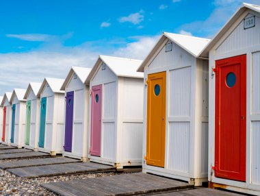 Fransa, Normandiya 'daki Le Treport plajında rengarenk kapılı geleneksel banyo kulübeleri.