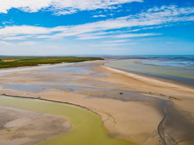Le Mont Saint Michel, Kuzey Fransa 'da alçak gelgit sırasında ünlü manastırı çevreleyen renkli kum düzlüklerinin etkileyici manzarası.