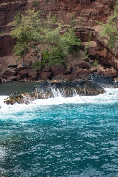 Ondas oceânicas a cair na costa rochosa da ilha. Espalhando ondas oceânicas e pedras. Red Sand Beach, Maui in em havaiano. — Fotografia de Stock