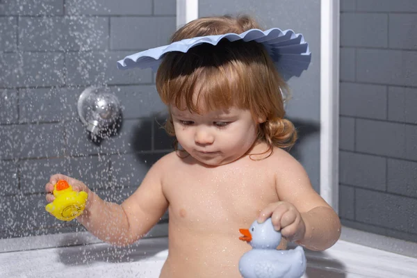 A gyerek a fürdőszobában habbal játszik. Babaköszöntő. Gyerek portréja, ahogy habos fürdőben fürdik.. — Stock Fotó