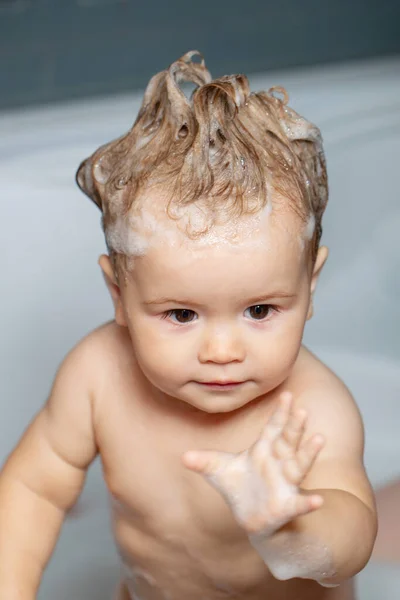 Kind baden im Badezimmer. Lustiges fröhliches Baby badet in Badewanne mit Wasser und Schaum. Kinderhygiene. — Stockfoto