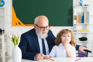 Öğretmen ve okul çocuğu okulda ödev yapıyor..