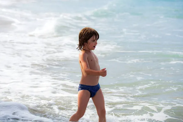 Ragazzo che gioca sulla spiaggia. Vacanze estive. Weekend estivo per bambini. Bambino all'oceano. — Foto Stock