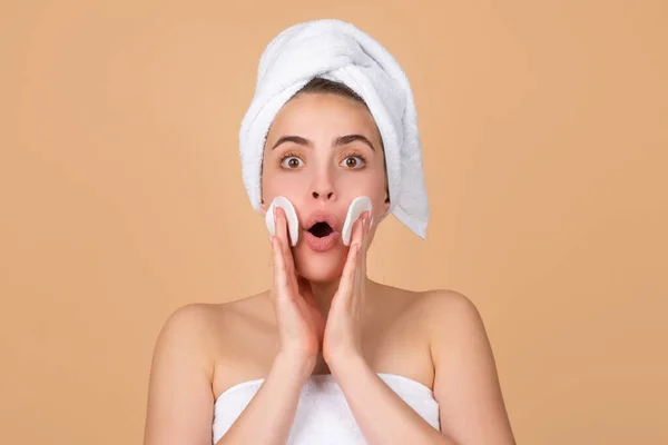 Excited beautiful woman with clean skin. Girl beauty face care. Facial treatment. Spa skin care, beauty woman wearing hair towel after beauty treatment. Beautiful perfect skin, isolated beige. — Stock Photo, Image