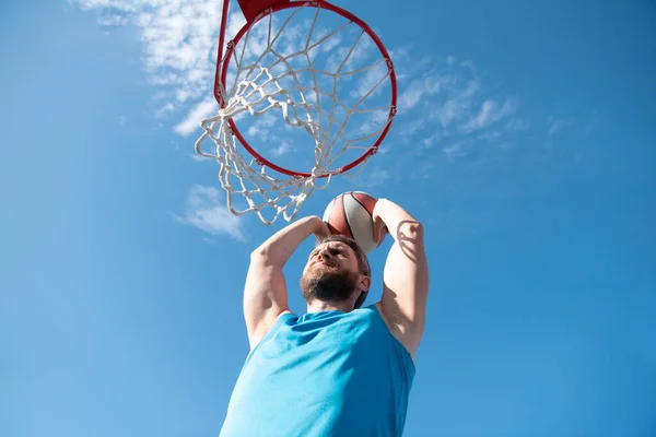 Sportovní muži hrají basketbal venku za slunečného dne. — Stock fotografie