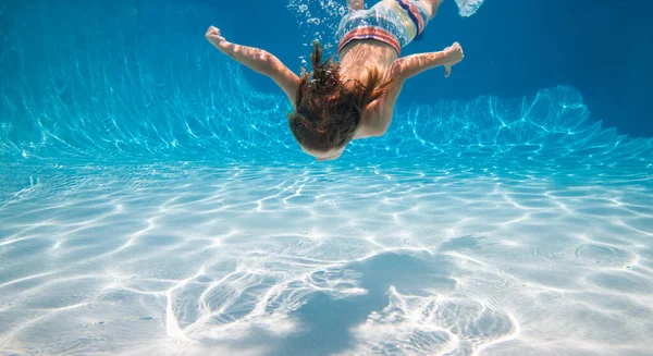 Een jongen die onder water zwemt. Zomervakantie met kinderen in een tropisch resort. Jongetje onder water. — Stockfoto