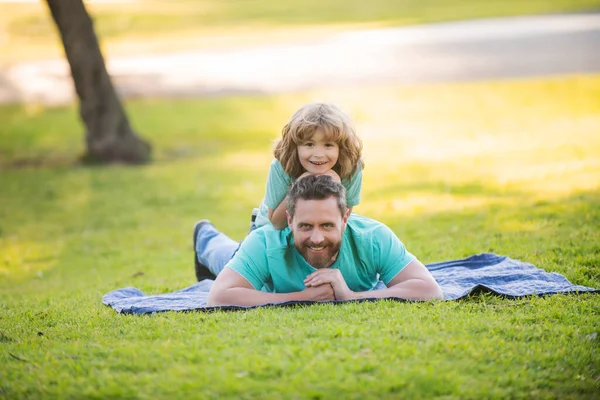Szczęśliwy ojciec i syn cieszący się letnim czasem na wakacjach w słonecznym parku. — Zdjęcie stockowe