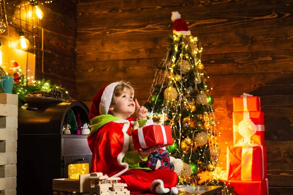 A criança a cara alegre adquiriu o presente na meia de Natal. É um milagre. Ano Novo. Criança duende. Conceito de cartão de presente. Serviço de presentes. Presentes de Natal. Pequeno génio. Família com crianças celebrando o Natal em casa. — Fotografia de Stock