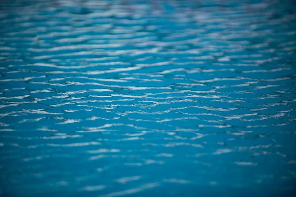 Sfondo d'acqua. Acqua blu, increspature e riflessi. Texture della superficie dell'acqua e del fondo piastrellato. — Foto Stock