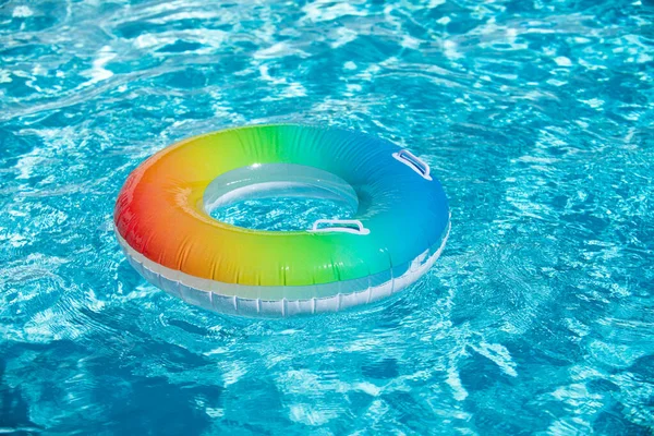Flotador de la piscina, anillo flotando en una refrescante piscina azul. Fondo de verano. — Foto de Stock