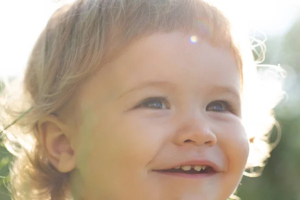 Närbild porträtt av ett sött litet barn, beskärt ansikte. Begreppet barndom och föräldraskap. Bebisen ler, gulligt leende. — Stockfoto