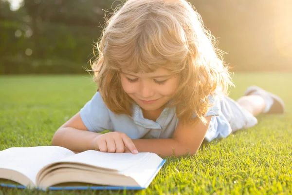 Детская книжка на травяном фоне. Дети читают книгу в парке. — стоковое фото