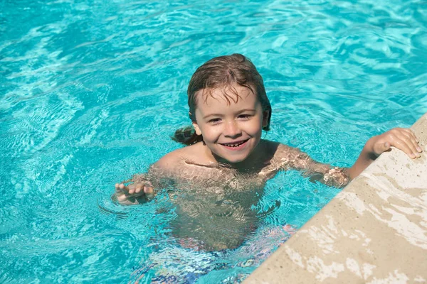 Pojkträning simning. Söt pojke simma i poolen, sommar vatten bakgrund med kopia utrymme. Roliga barn ansikte. — Stockfoto
