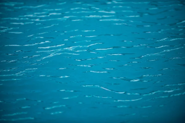 Fondo de agua azul en la piscina con reflejo solar, ondulación de la ola de agua en la piscina. Fondo de agua clara. — Foto de Stock