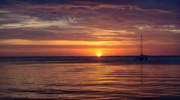 Barco no mar ao pôr-do-sol. Barcos à vela com velas. Iate oceânico navegando no oceano. — Fotografia de Stock