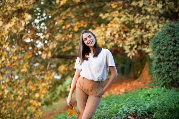 Beautiful girl enjoying autumn. Young woman with autumn maple leaves, season and people concept. — Stock Photo, Image