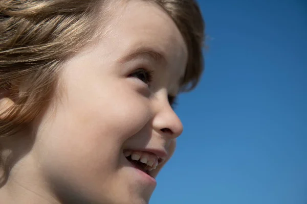 Retrato macro de los niños, primer plano de la cabeza del niño lindo en el cielo azul con espacio de copia. —  Fotos de Stock