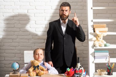 İlkokulda küçük bir kız öğrenciyle ciddi bir öğretmen..