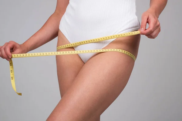 날씬 한 젊은 여자는 다이어트 후 엉덩이 테이프로 허리를 재고 있다. 체중 감소에 대한 개념. — 스톡 사진