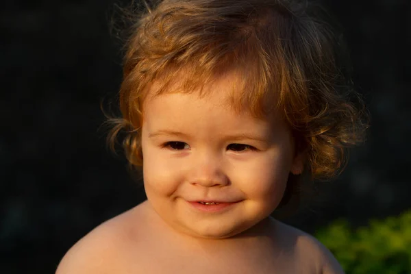 Close-up portret van een schattige kleine baby op zonnige dag. Jeugd en ouderschap concept. Lachende baby, schattige glimlach. — Stockfoto