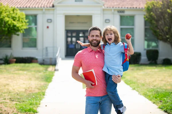 Father leads a little child school boy in first grade. Father supports and motivates son. Kid going to primary school. — Stock Photo, Image