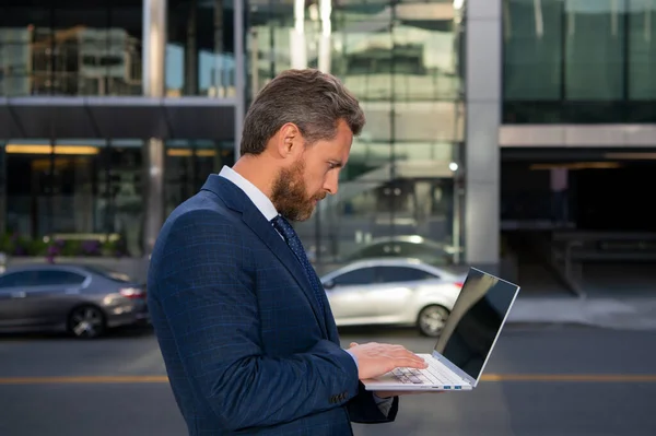 Ritratto di bell'uomo d'affari che utilizza il computer portatile all'aperto. — Foto Stock