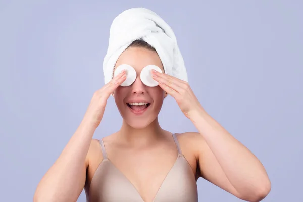 Funny beautiful girl with clean fresh skin. Facial treatment. Cosmetology beauty and spa. Girl apply skincare cream on face, woman wrap towel on head put facial creme on doing morning healthy skin. — Stock Photo, Image