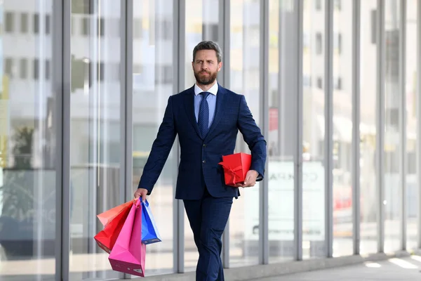 Επιχειρηματίας μεταφέρουν τσάντες ψώνια, με τα πόδια στην πόλη. — Φωτογραφία Αρχείου